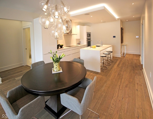 dining room with baseboards, a chandelier, wood finished floors, and recessed lighting