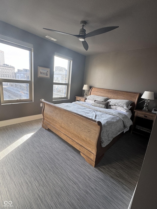 carpeted bedroom featuring ceiling fan, visible vents, and baseboards