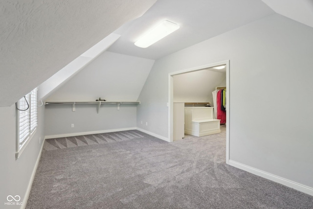 additional living space featuring lofted ceiling, carpet flooring, and baseboards