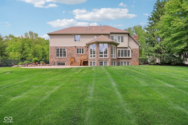 rear view of property featuring brick siding, a patio, a chimney, a wooden deck, and stairway