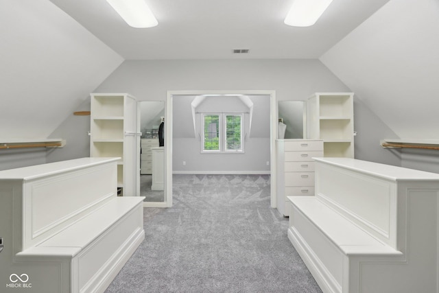 walk in closet featuring lofted ceiling and light carpet