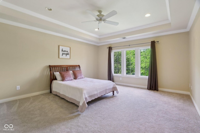 carpeted bedroom featuring a raised ceiling, crown molding, baseboards, recessed lighting, and ceiling fan