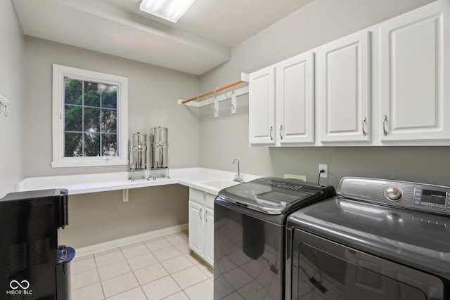 laundry room with cabinet space, washer and clothes dryer, and light tile patterned floors