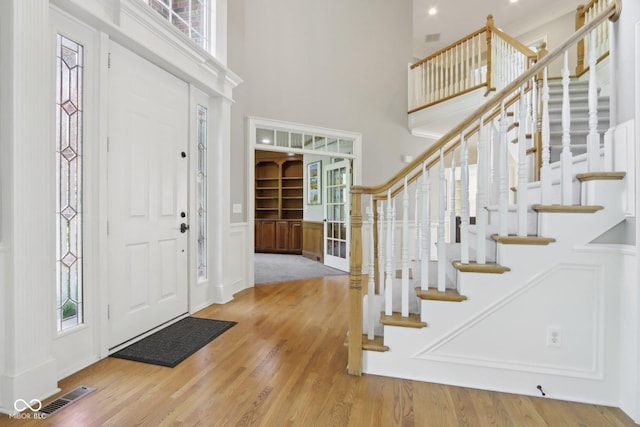 entrance foyer featuring a high ceiling, wood finished floors, and stairway
