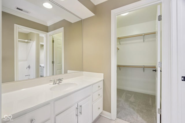 full bathroom featuring a spacious closet, vanity, crown molding, baseboards, and a shower