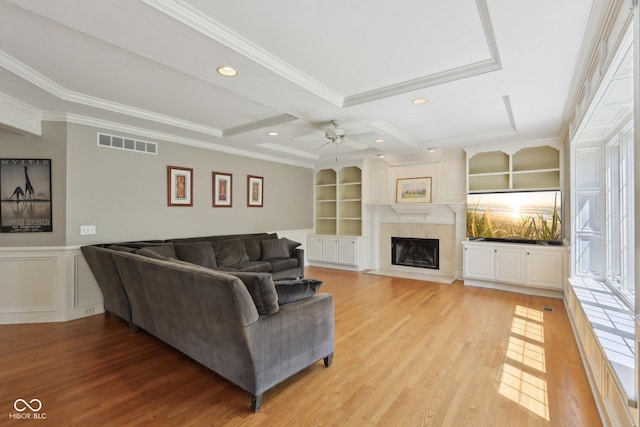 living area featuring ceiling fan, crown molding, light wood-type flooring, a premium fireplace, and recessed lighting