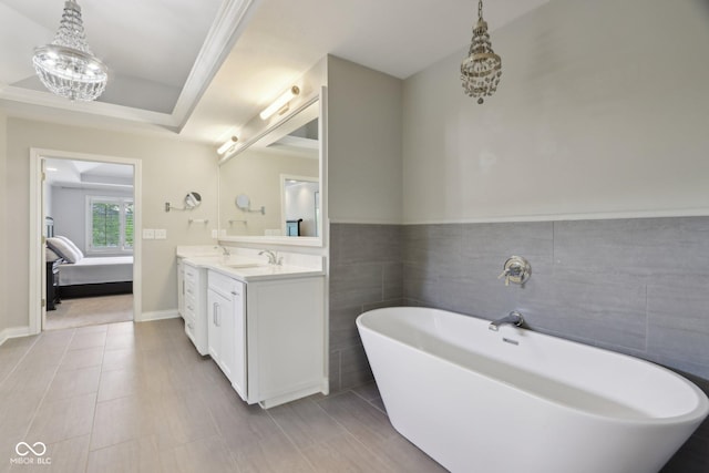 bathroom with a soaking tub, double vanity, tile walls, ensuite bath, and a chandelier