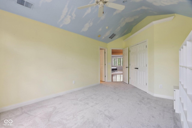 unfurnished bedroom featuring carpet, vaulted ceiling, baseboards, a closet, and a ceiling fan