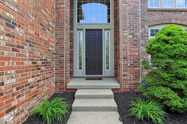 entrance to property featuring brick siding