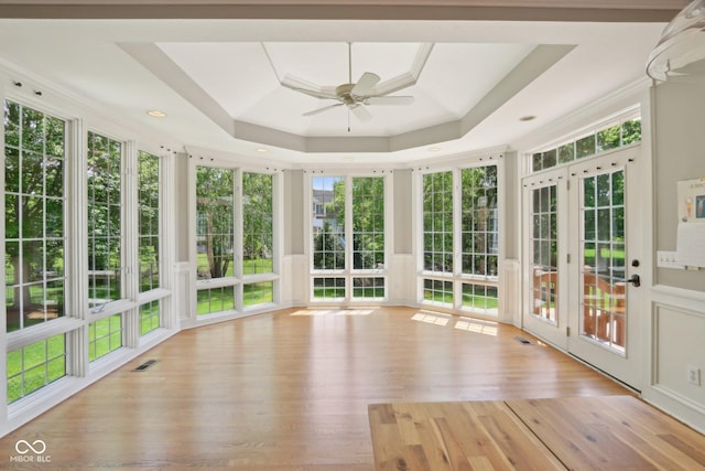 unfurnished sunroom with a tray ceiling and wood finished floors
