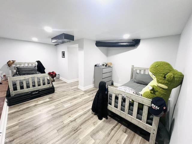 bedroom with recessed lighting, wood finished floors, and baseboards