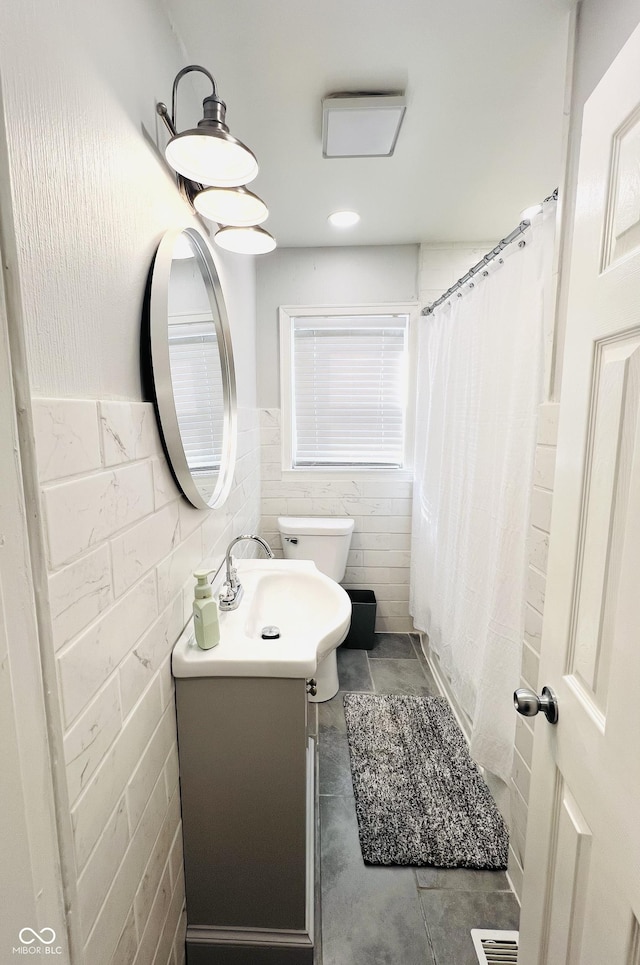 bathroom featuring visible vents, toilet, a shower with curtain, vanity, and tile walls