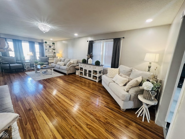 living room with built in features, hardwood / wood-style floors, and recessed lighting