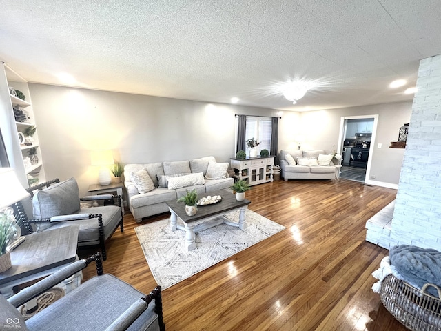 living area with a textured ceiling and wood finished floors