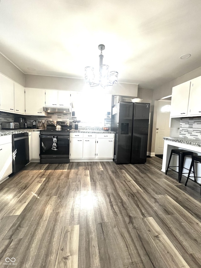 kitchen with under cabinet range hood, white cabinetry, backsplash, dark wood-style floors, and black appliances