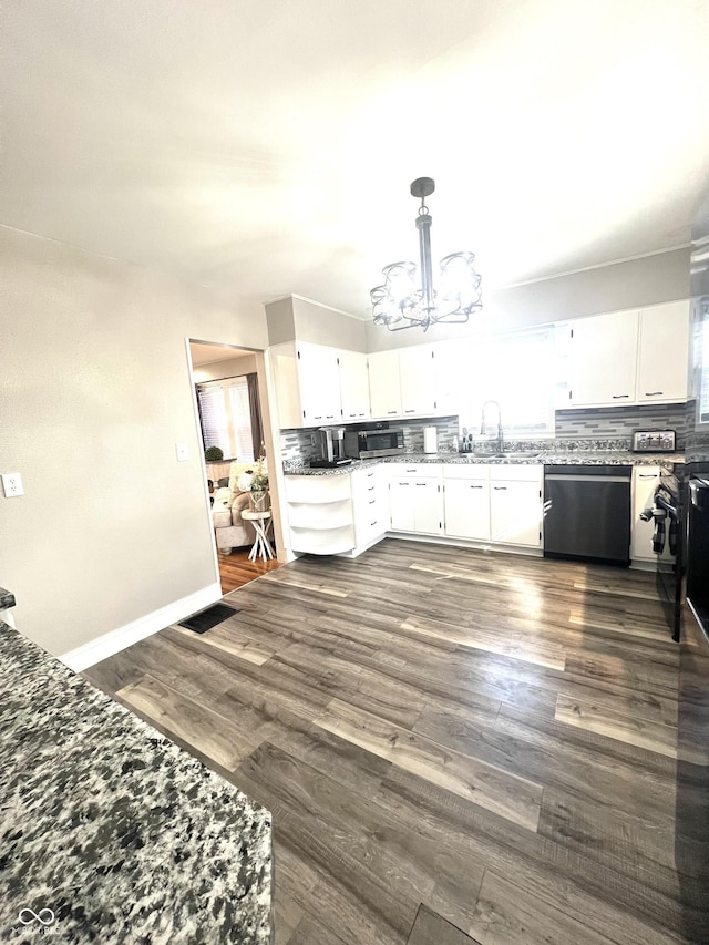 kitchen with stainless steel appliances, a sink, white cabinetry, and an inviting chandelier