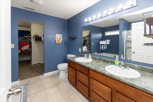 bathroom with visible vents, a sink, a shower stall, and toilet