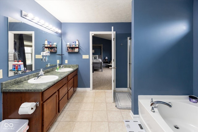 full bathroom with double vanity, a sink, a textured ceiling, and ensuite bathroom