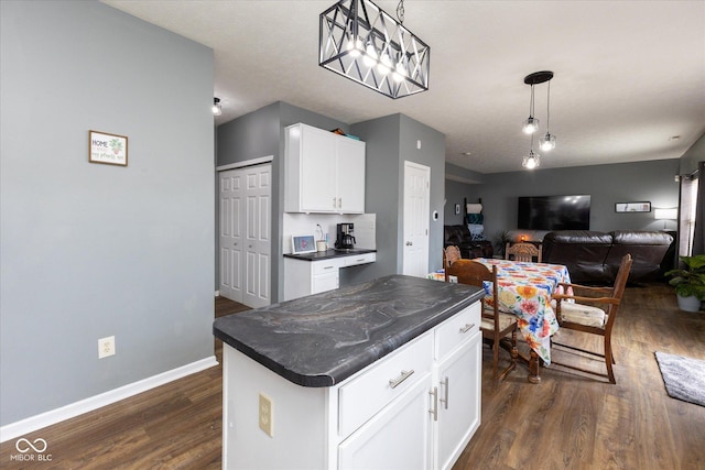 kitchen featuring baseboards, dark countertops, open floor plan, dark wood-style flooring, and white cabinetry