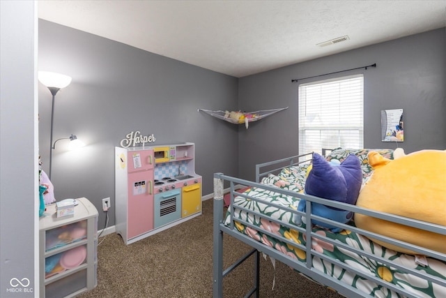 bedroom with carpet floors, visible vents, a textured ceiling, and baseboards