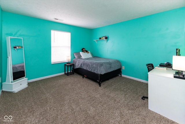 carpeted bedroom featuring visible vents, baseboards, and a textured ceiling