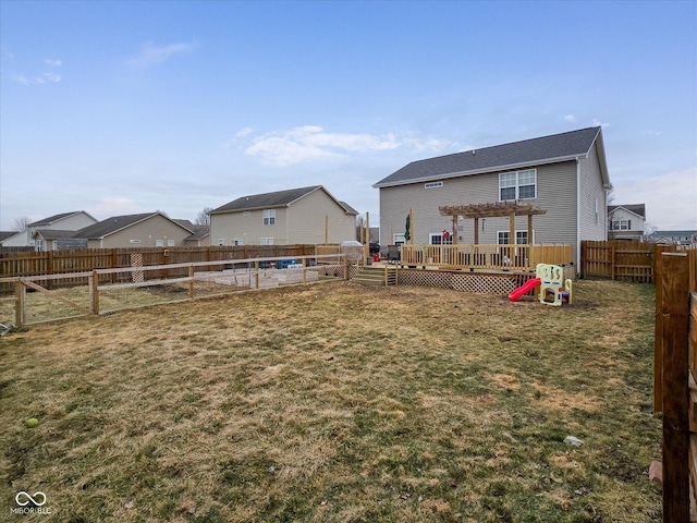 back of house with a fenced backyard, a pergola, and a yard