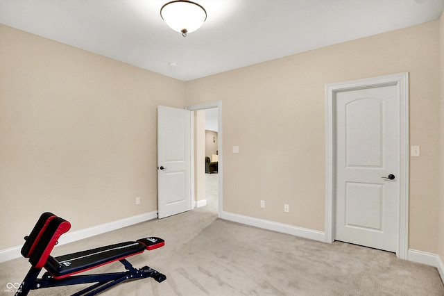 exercise room featuring carpet and baseboards