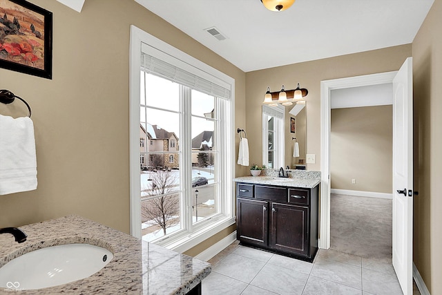 bathroom with tile patterned flooring, two vanities, visible vents, and a sink