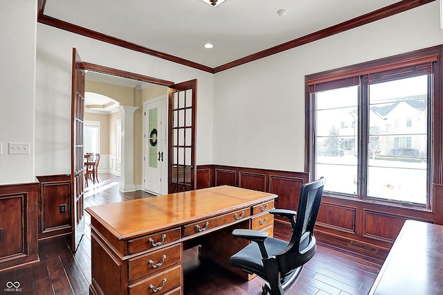 office with dark wood-type flooring, arched walkways, wainscoting, crown molding, and decorative columns