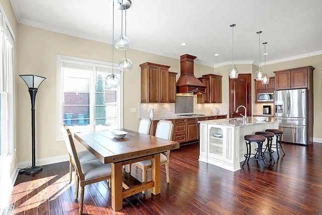 kitchen featuring a kitchen bar, tasteful backsplash, dark wood finished floors, stainless steel appliances, and custom exhaust hood