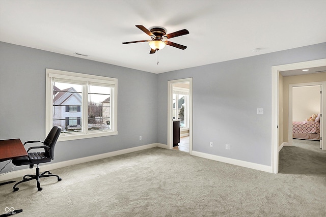 carpeted office space with visible vents, baseboards, and a ceiling fan