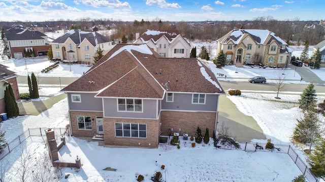 snowy aerial view with a residential view