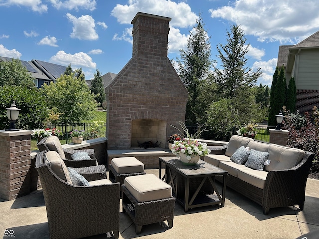 view of patio / terrace featuring an outdoor living space with a fireplace and fence