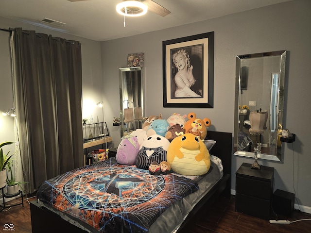 bedroom featuring wood finished floors, visible vents, and baseboards