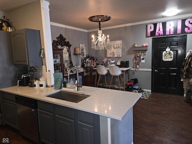 kitchen featuring a sink, light countertops, ornamental molding, stainless steel dishwasher, and dark wood finished floors