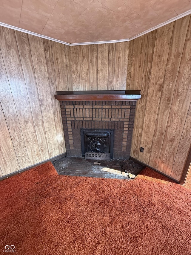 interior details featuring wooden walls, ornamental molding, a fireplace, and carpet floors