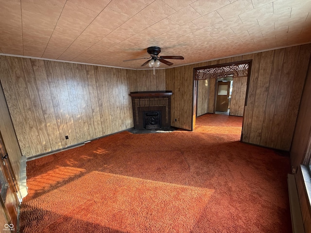 unfurnished living room with wooden walls, ceiling fan, and carpet