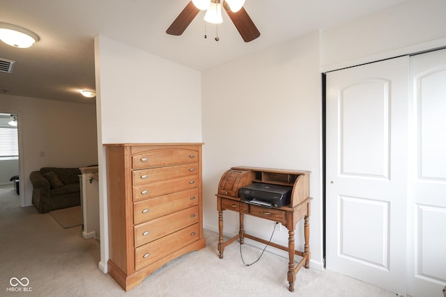 office space with a ceiling fan, light colored carpet, and visible vents