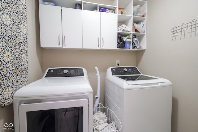 washroom with cabinet space and washing machine and clothes dryer