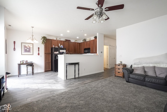 living area featuring ceiling fan with notable chandelier, visible vents, light wood-style flooring, and recessed lighting