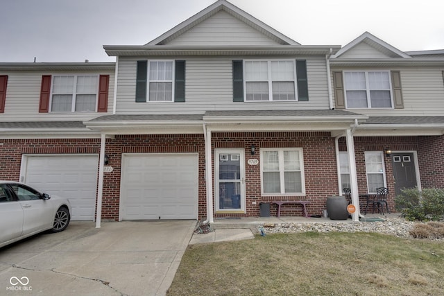 view of property with brick siding, driveway, and an attached garage