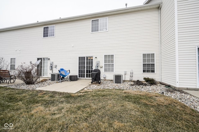 rear view of house featuring a patio area, central AC, and a yard