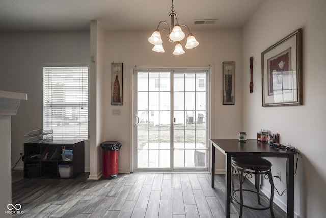 entryway with a notable chandelier, visible vents, and wood finished floors