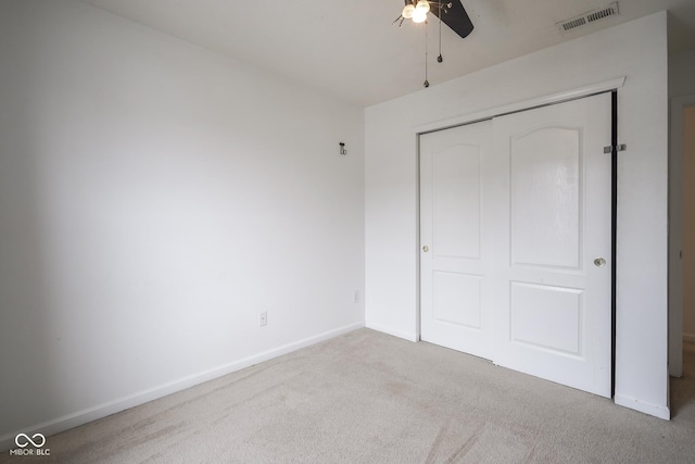 unfurnished bedroom featuring ceiling fan, carpet flooring, visible vents, baseboards, and a closet