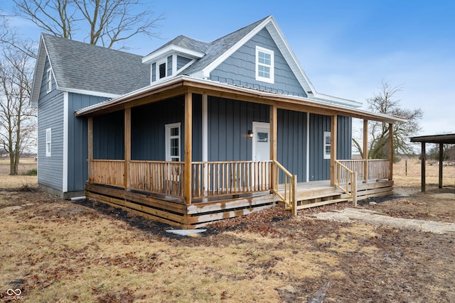 farmhouse with covered porch, board and batten siding, and roof with shingles