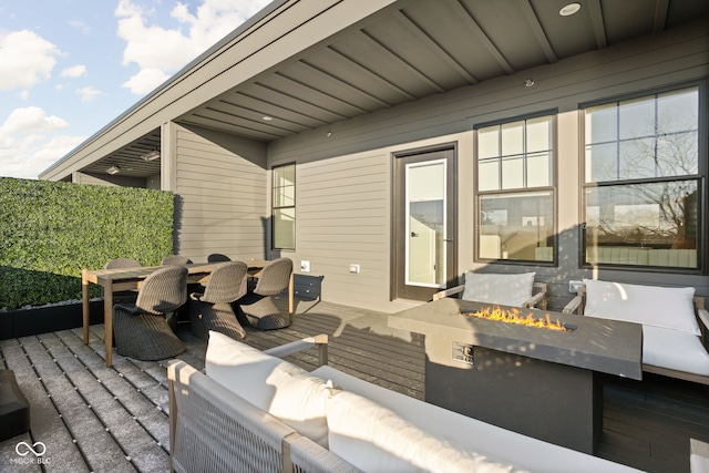 view of patio / terrace with outdoor dining space and an outdoor living space with a fire pit