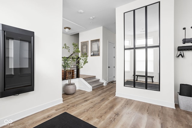 foyer entrance featuring light wood-style floors and baseboards