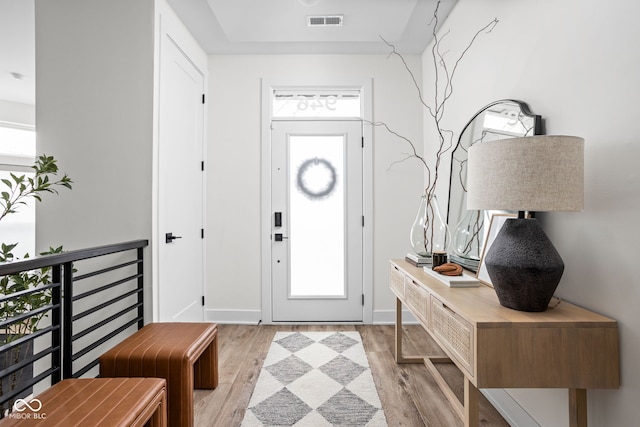 foyer with light wood-type flooring and visible vents