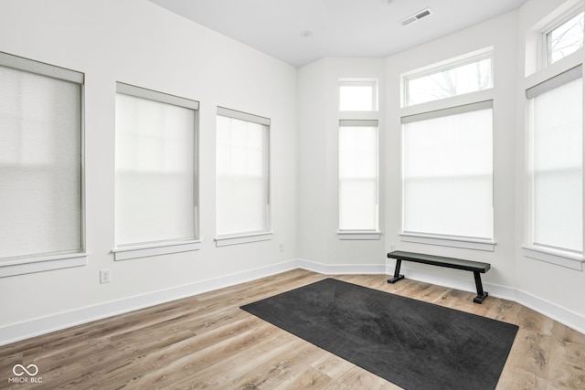 interior space with wood finished floors, visible vents, and baseboards