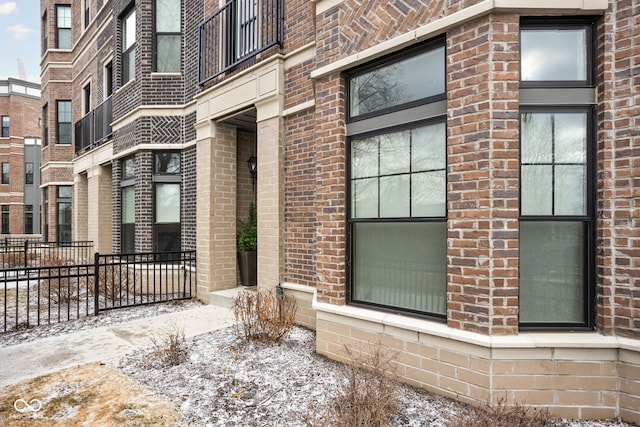 property entrance featuring brick siding and fence